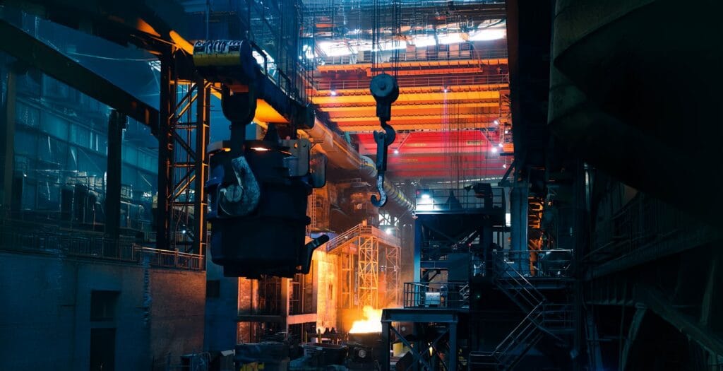 5 Key Tips for Choosing Steel Suppliers for B2B Export Inside a bustling steel factory with cranes and molten metal casting an intense glow.